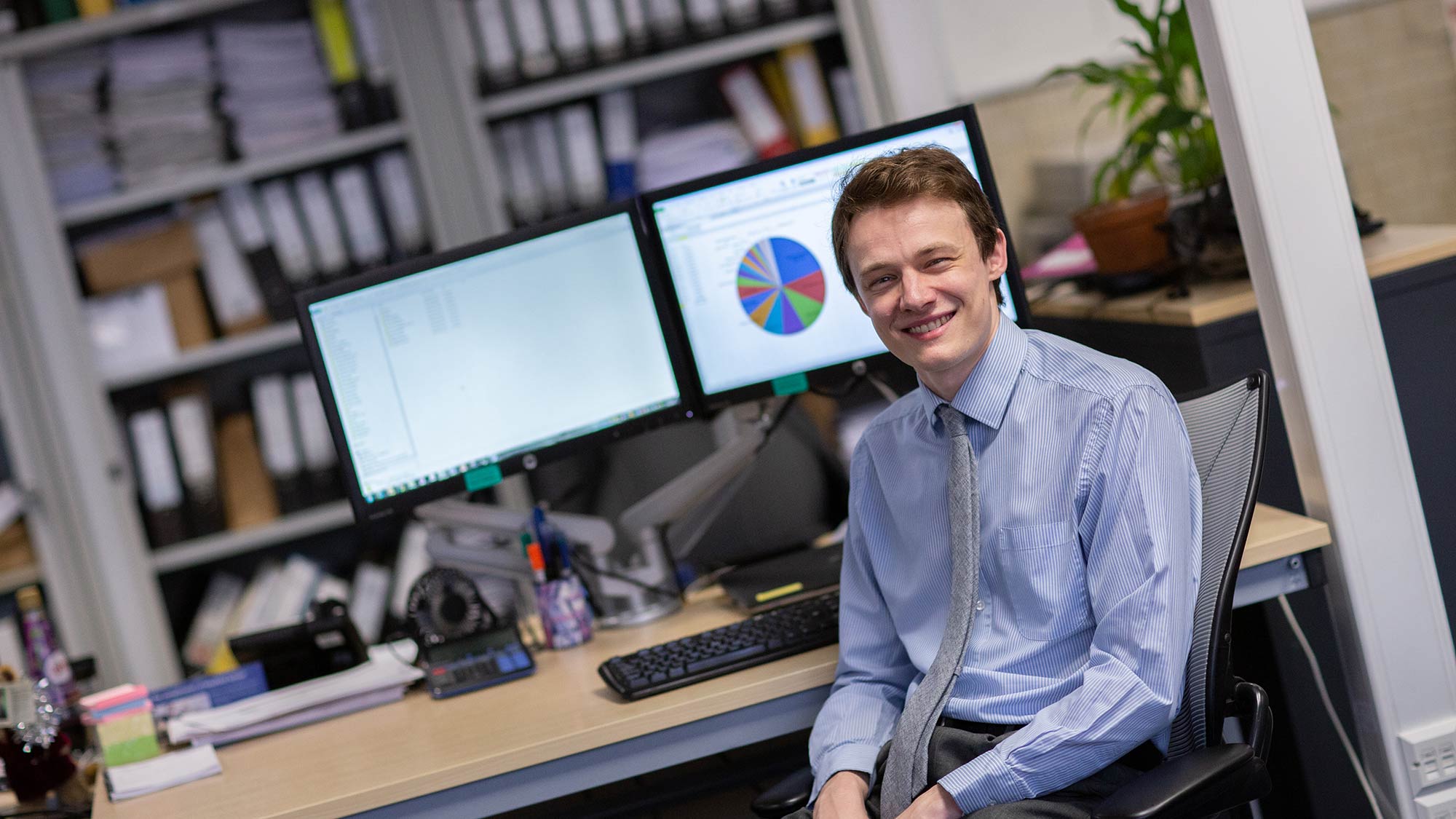 Man sat at his desk with two computer screens