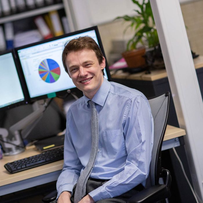 Man sat at his desk with two computer screens