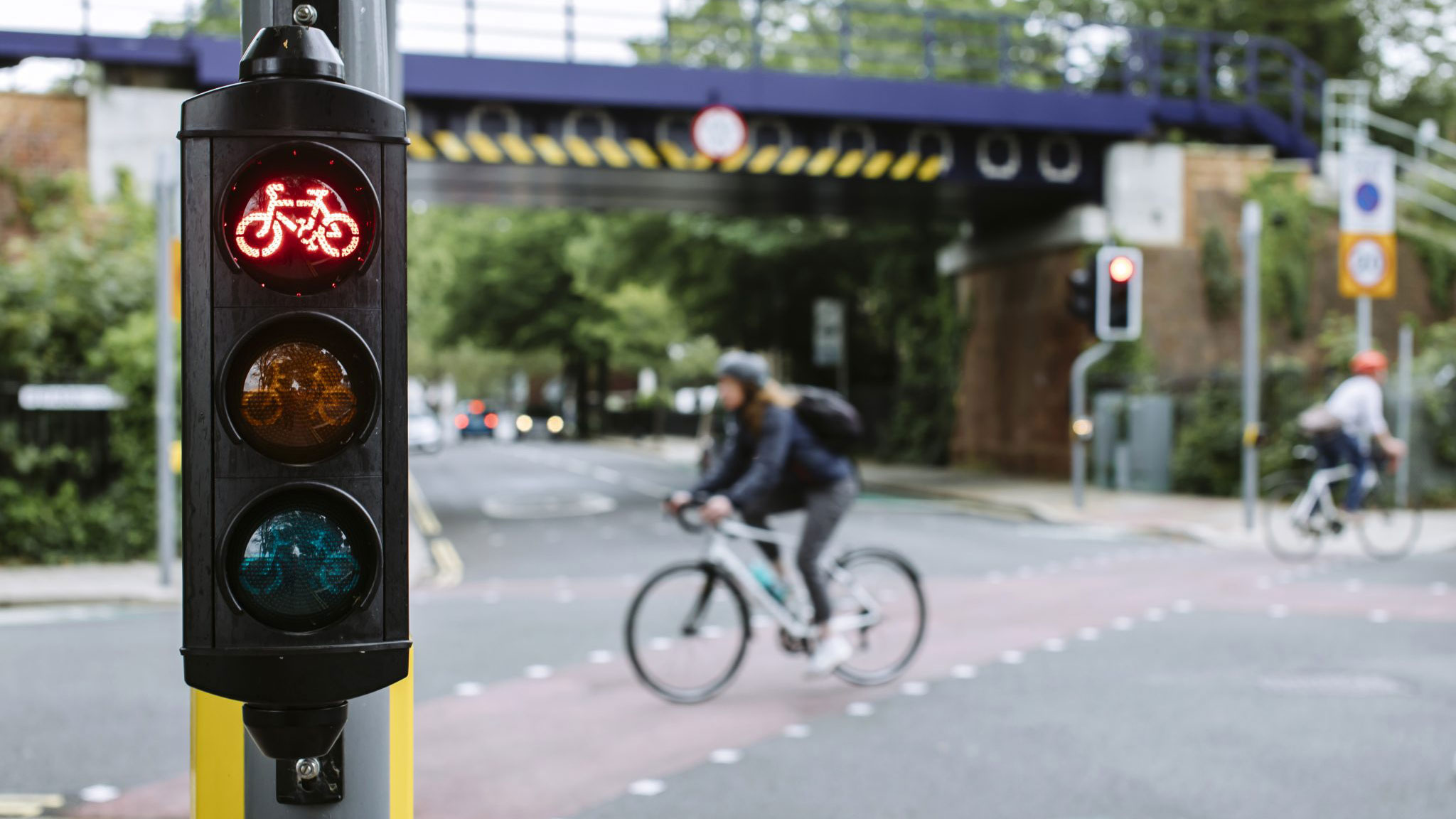 image of a person cycling passed a traffic lighted junction